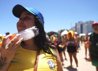 Com calor de 32°C, torcedores se refrescam e assistem jogo do Brasil em Copacabana